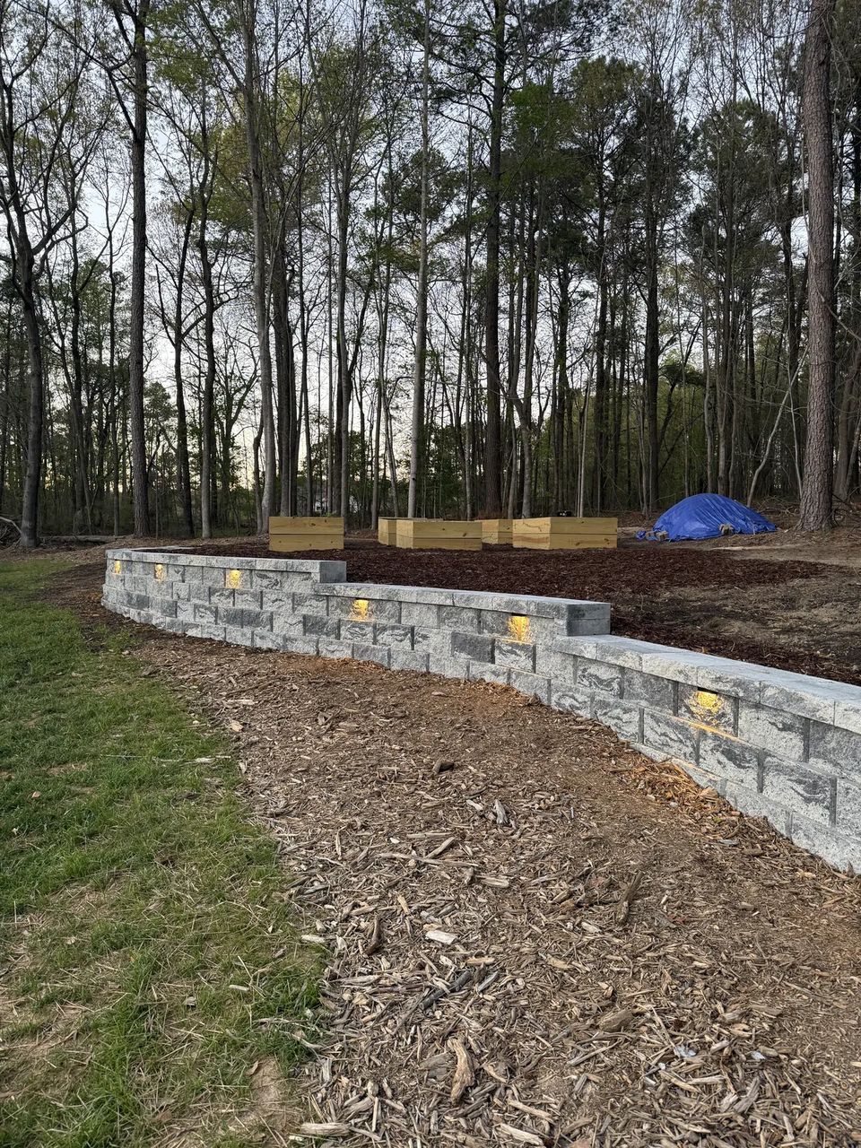 Install day: curved retaining wall going in with fresh backfill