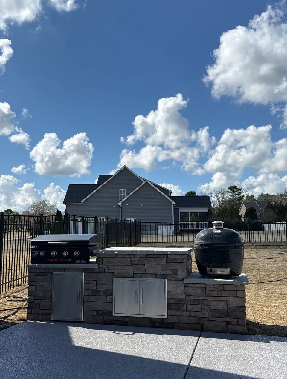 Grill island set at the edge of the patio by the fence