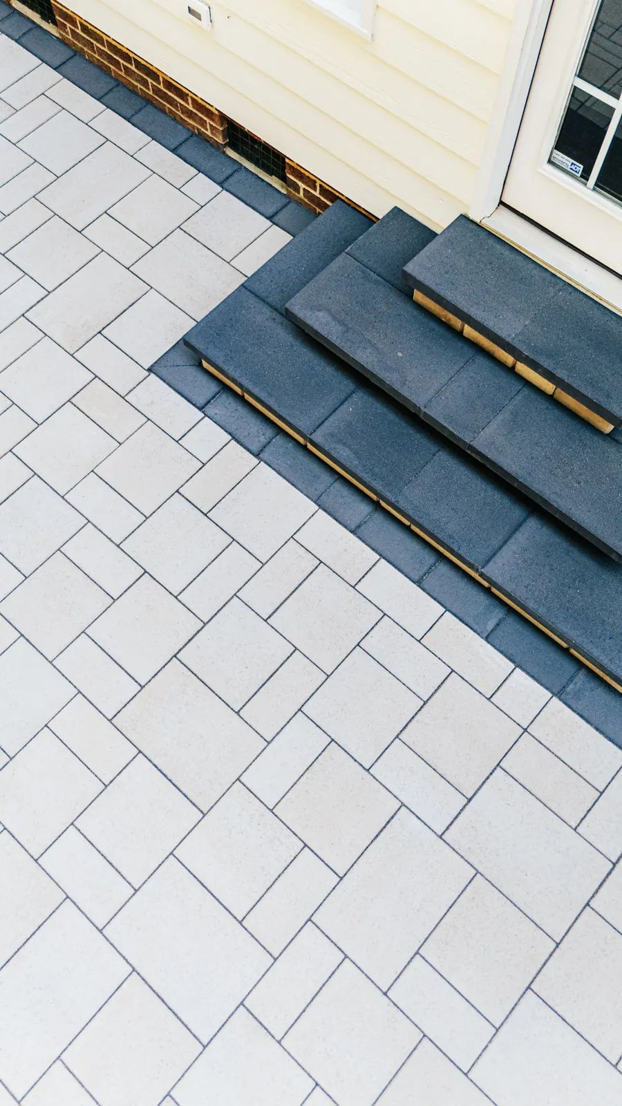 Dark border steps meeting the light paver field