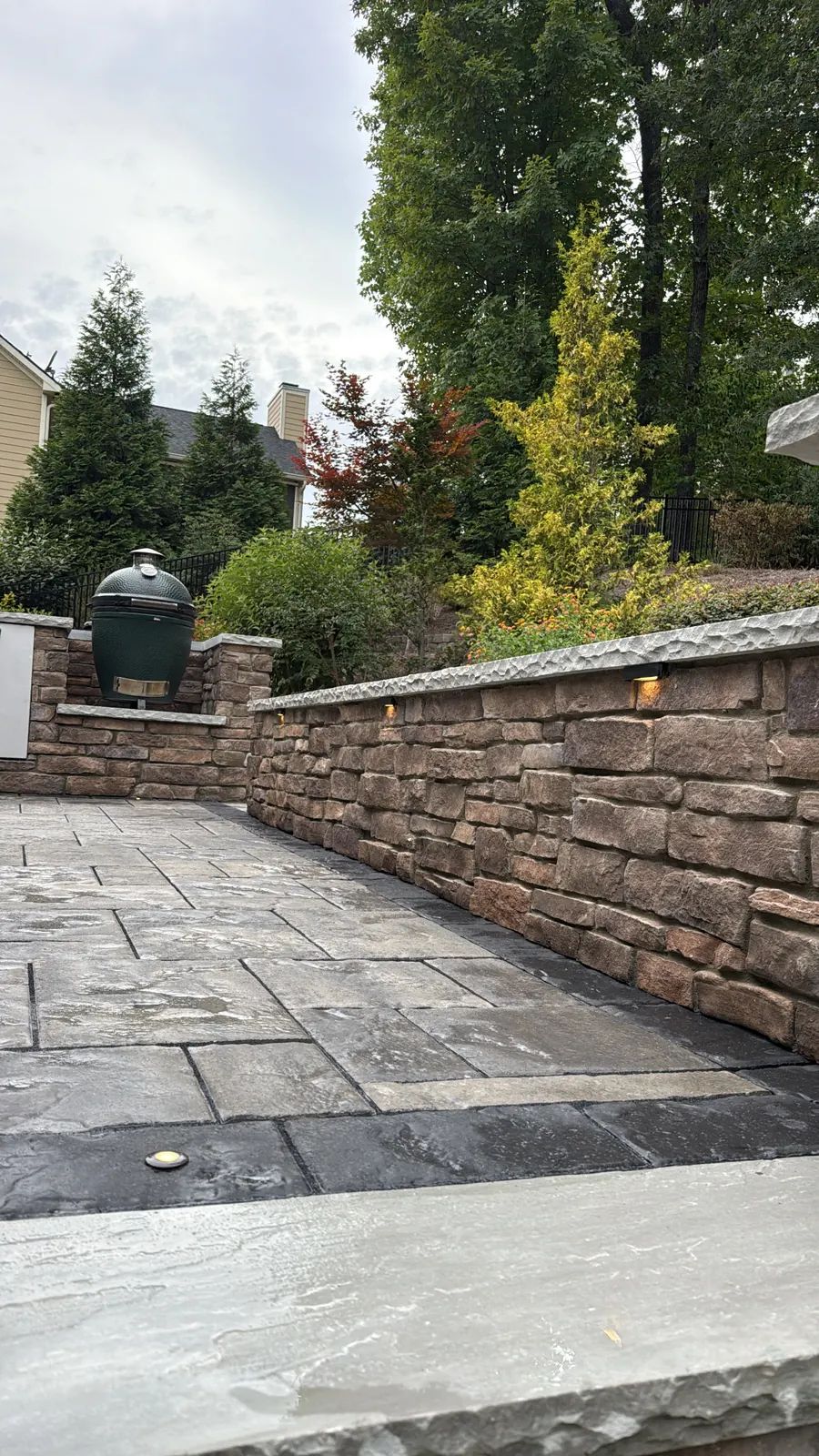 Stone seat wall with cap lights curving around the kitchen patio