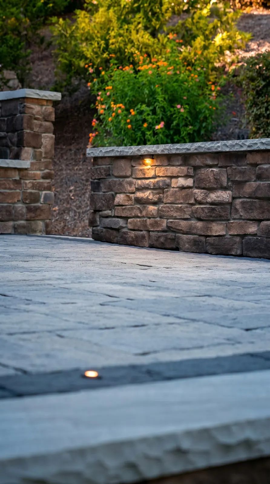 Stone seat wall cap with a light along the patio