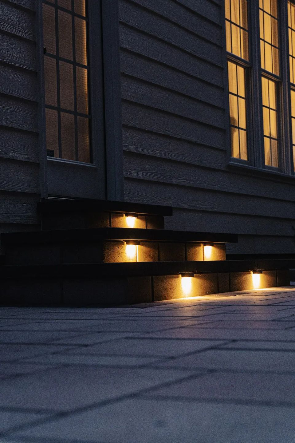 Step lights glowing under each tread at dusk