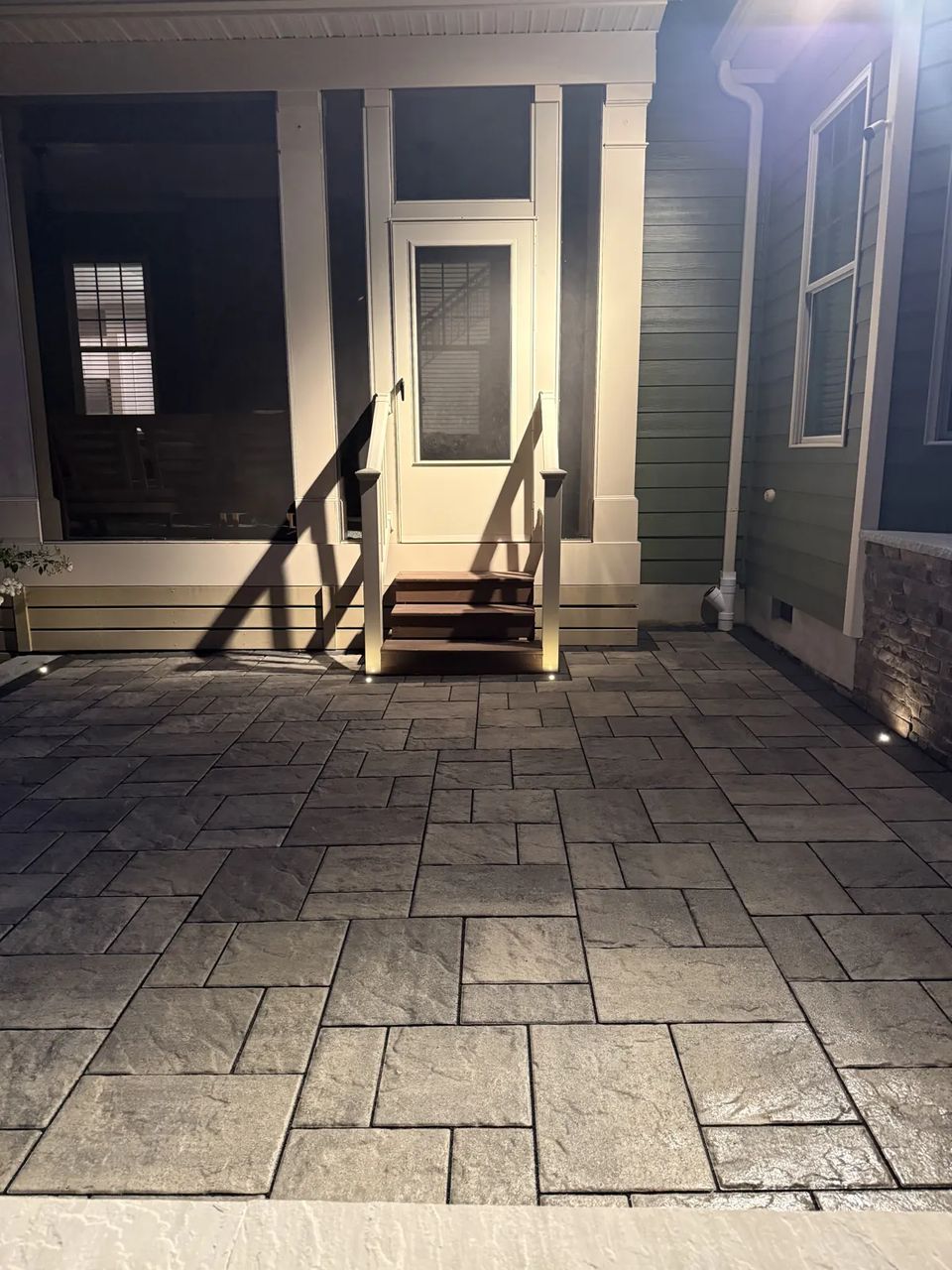 Patio leading to the screened porch door at dusk