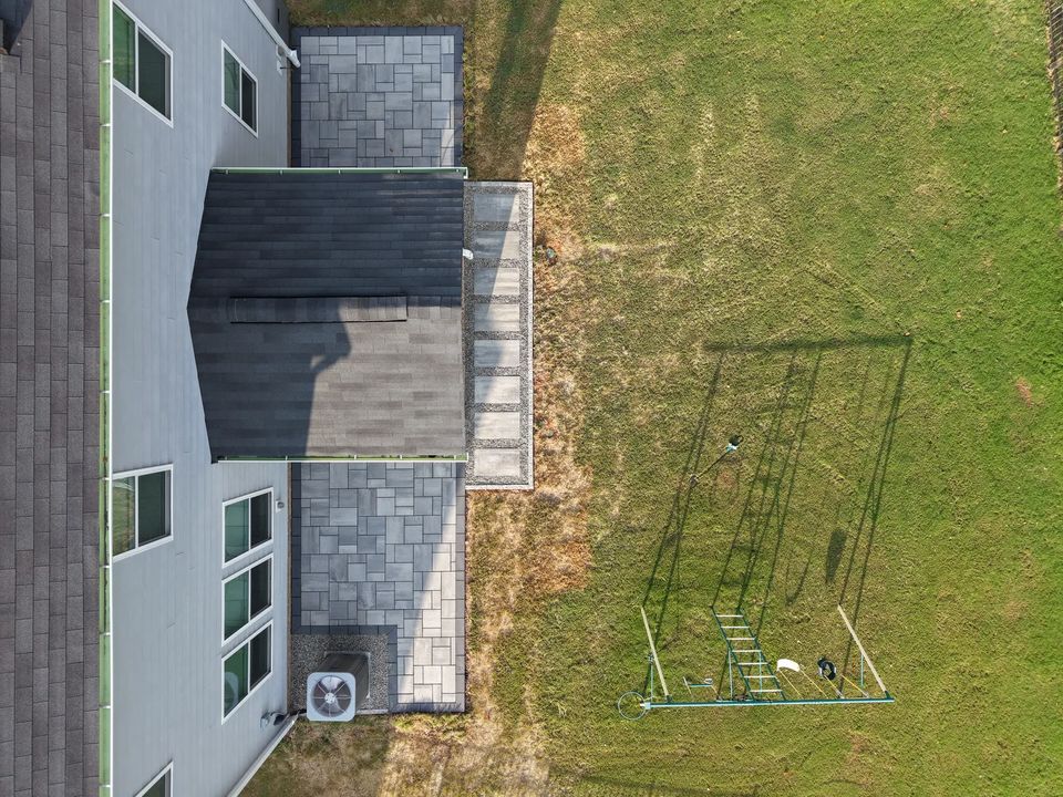 Drone view down the roof line to the patio and lawn