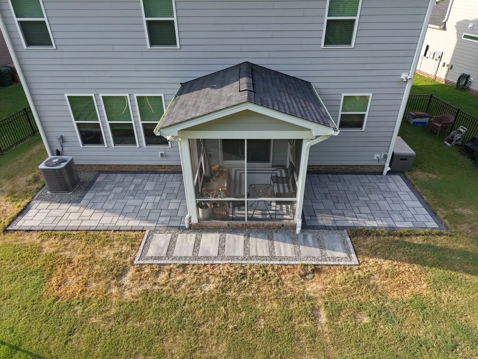 Drone view of a paver patio wrapping a screened porch