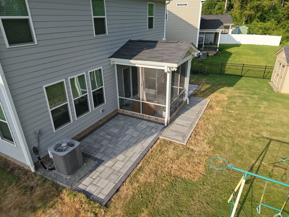 Patio and screened porch seen from the corner of the yard