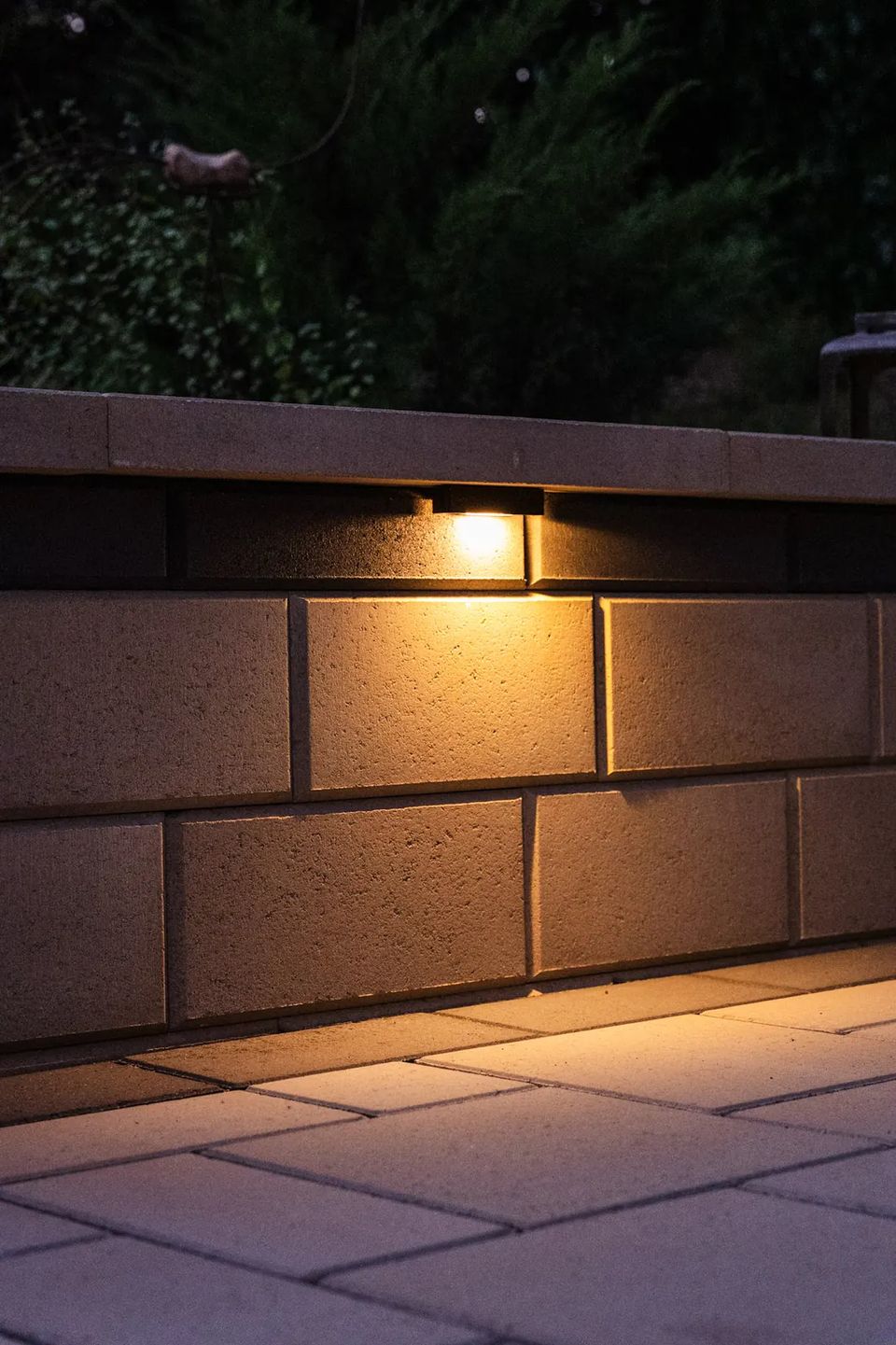 Under cap light washing down a block seat wall