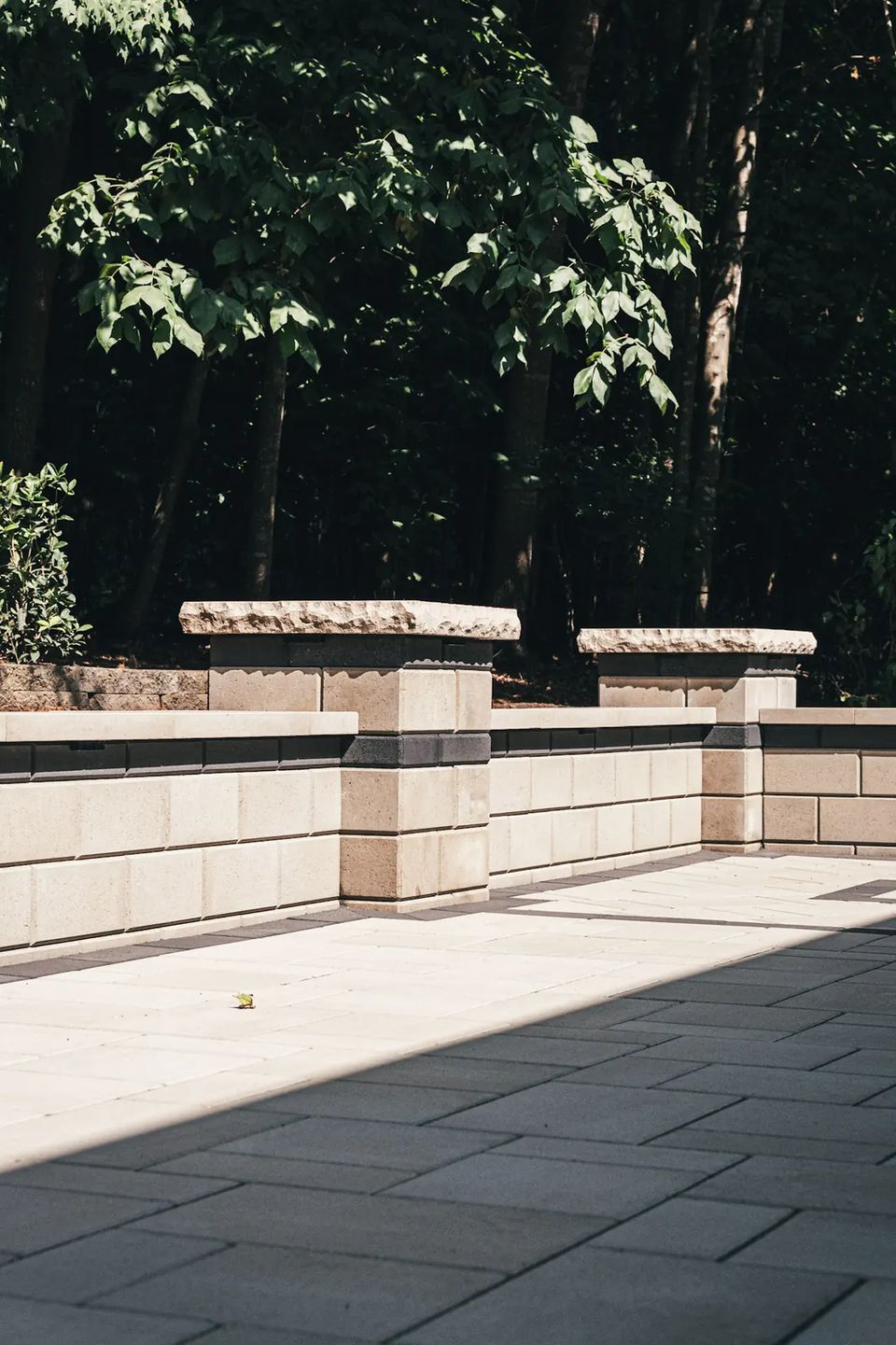 Seat wall and pillars running along the edge of a shaded patio