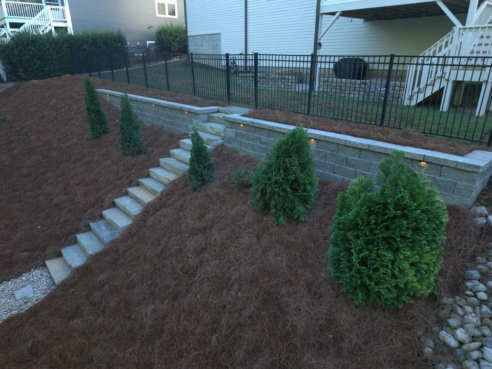 Planting beds and evergreens along the new retaining wall