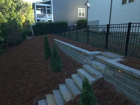 Stone stairs climbing the slope beside the retaining wall